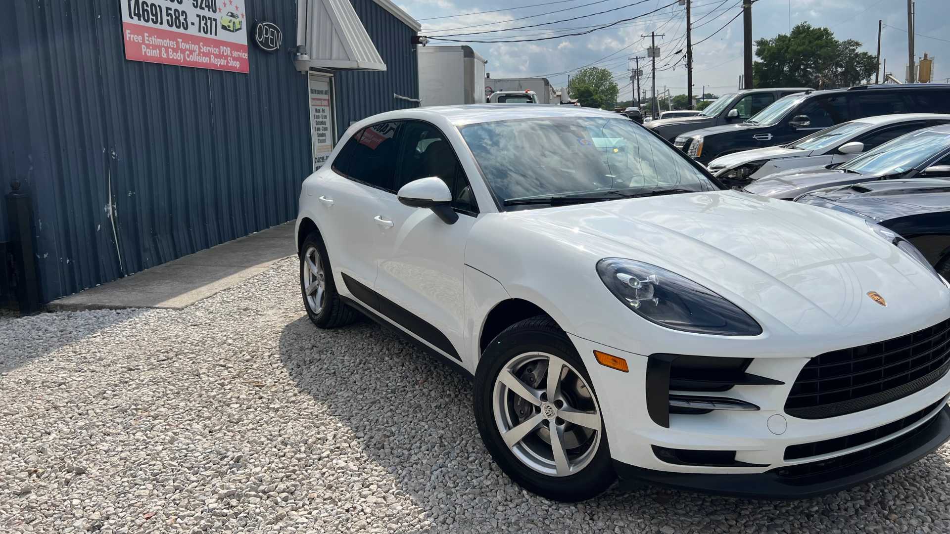 A white Porsche receiving paintless dent repair in our Garland shop.