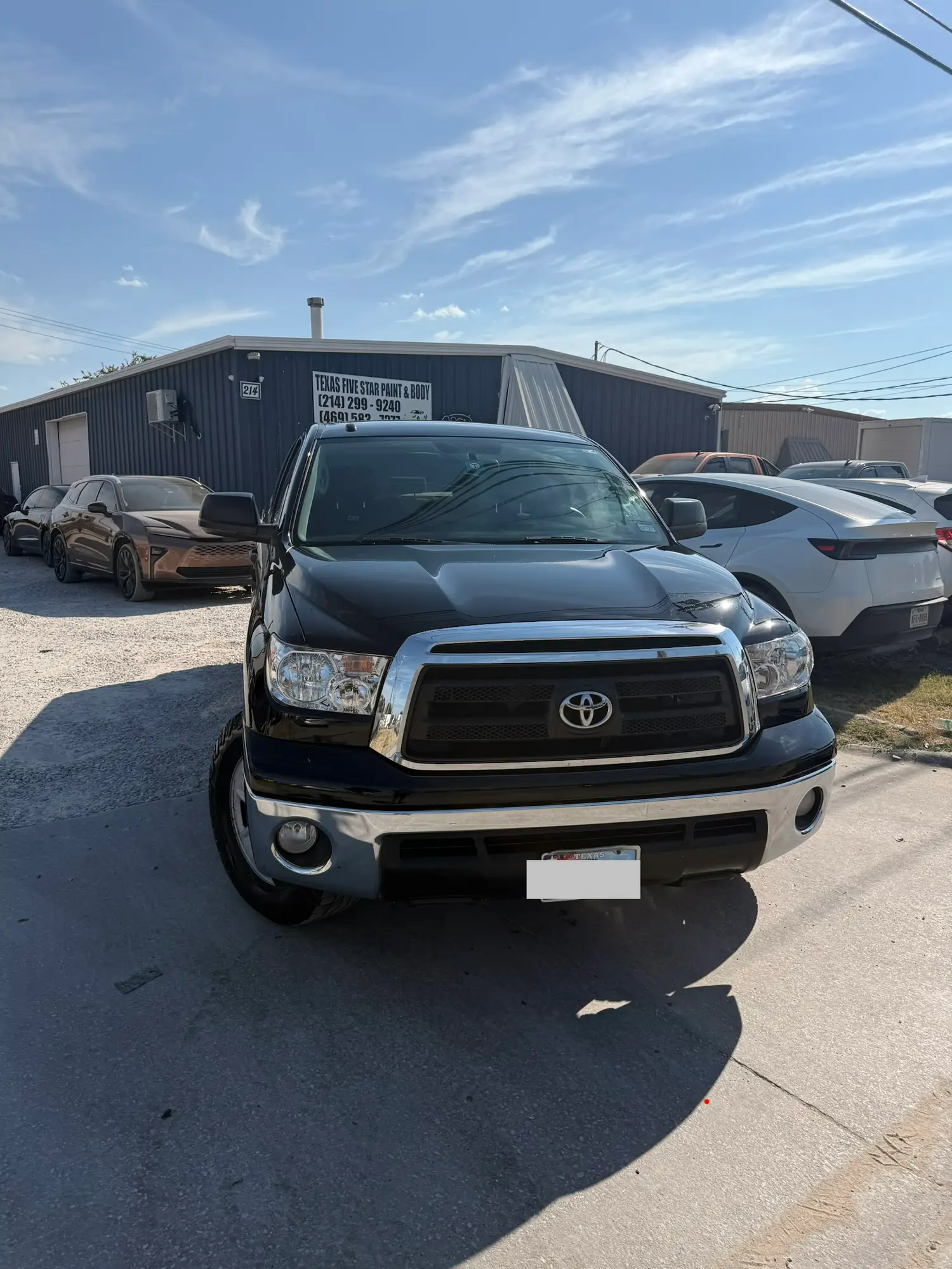 Black Toyota Tundra parked in front of the Texas Five Star Paint & Body shop