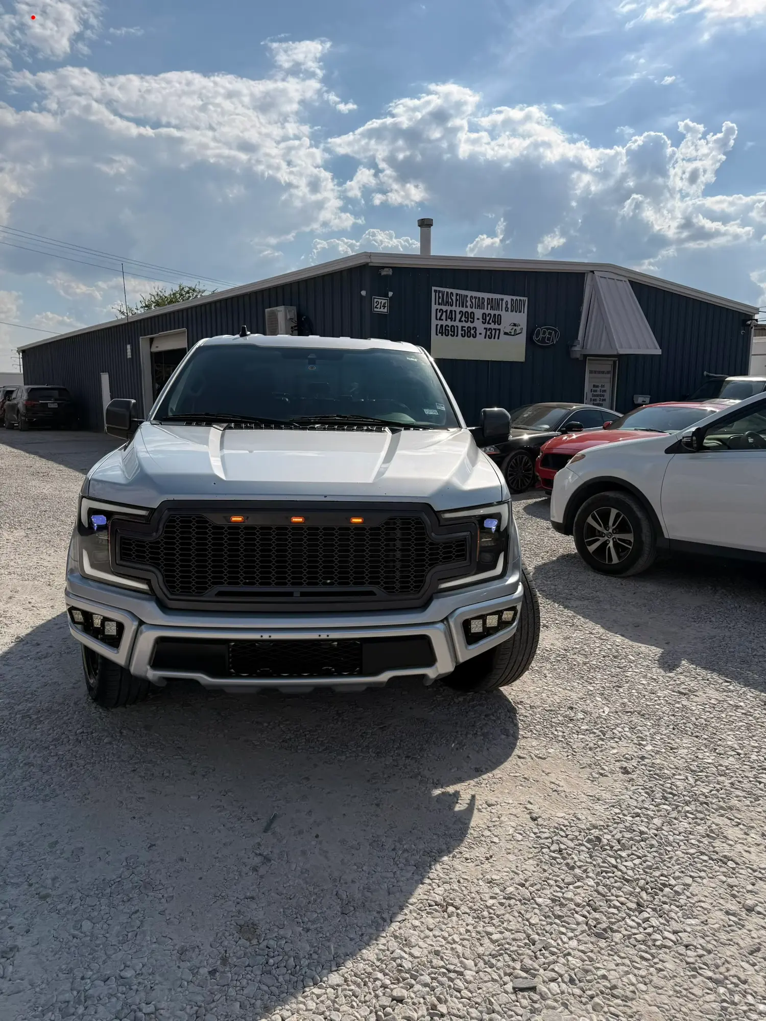 Silver GMC truck parked in front of the Texas Five Star Paint & Body shop